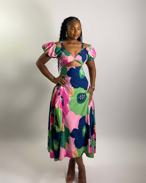 Woman wearing a colorful floral dress on a plain background