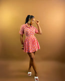Woman wearing a patterned skirt set against a brown background
