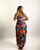 Woman wearing a colorful floral dress with a patterned top on a white background