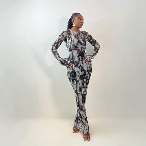 A model wearing a monochrome tie-dye mesh gown with a fitted silhouette and subtle bell sleeves.