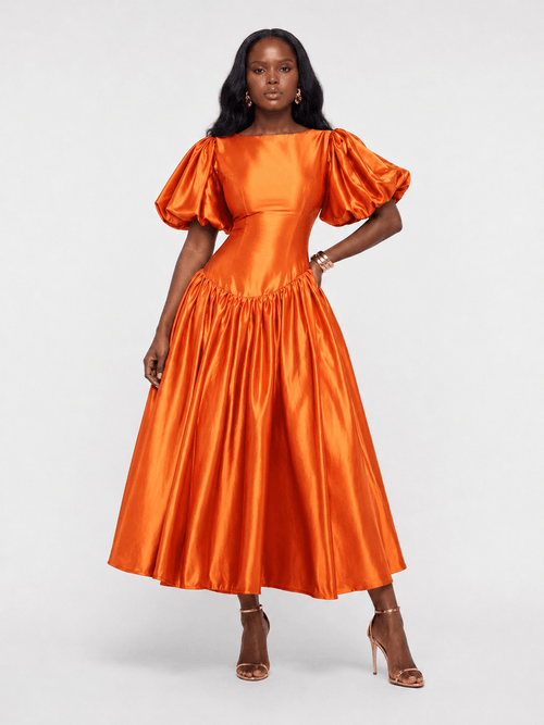 Woman wearing an orange satin dress with puff sleeves on a white background